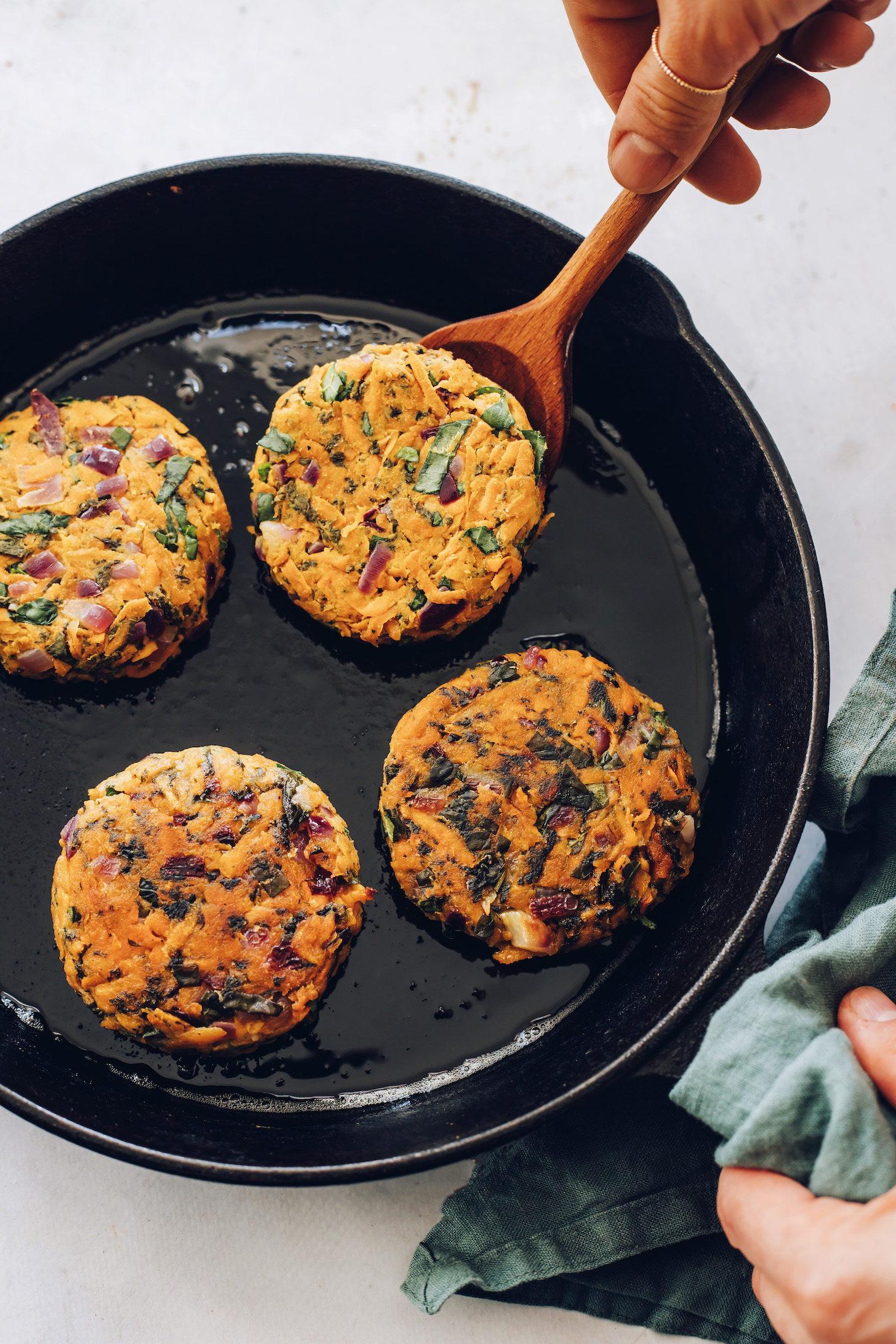 Partially cooked sweet potato fritters in a cast iron skillet