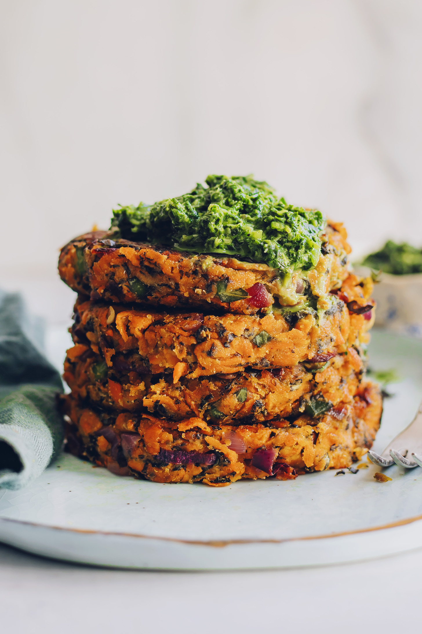 Stack of sweet potato fritters topped with mint chutney