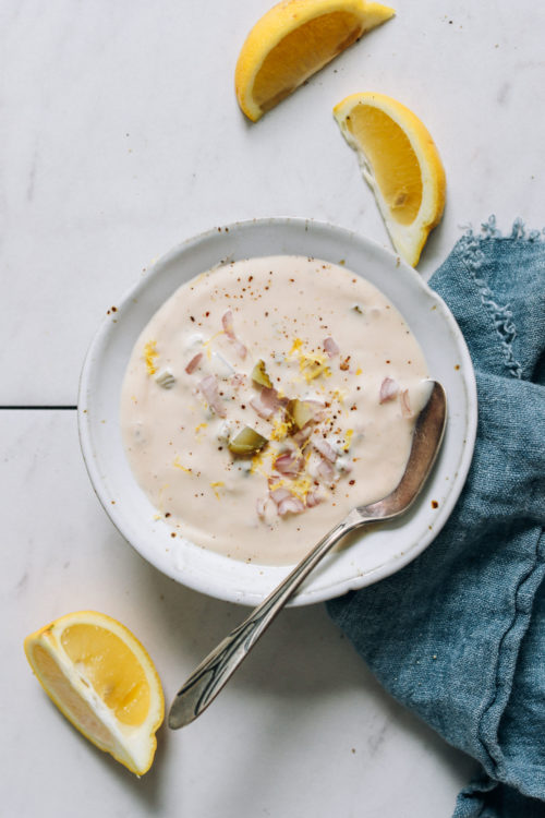Lemon wedges beside a bowl of vegan tartar sauce