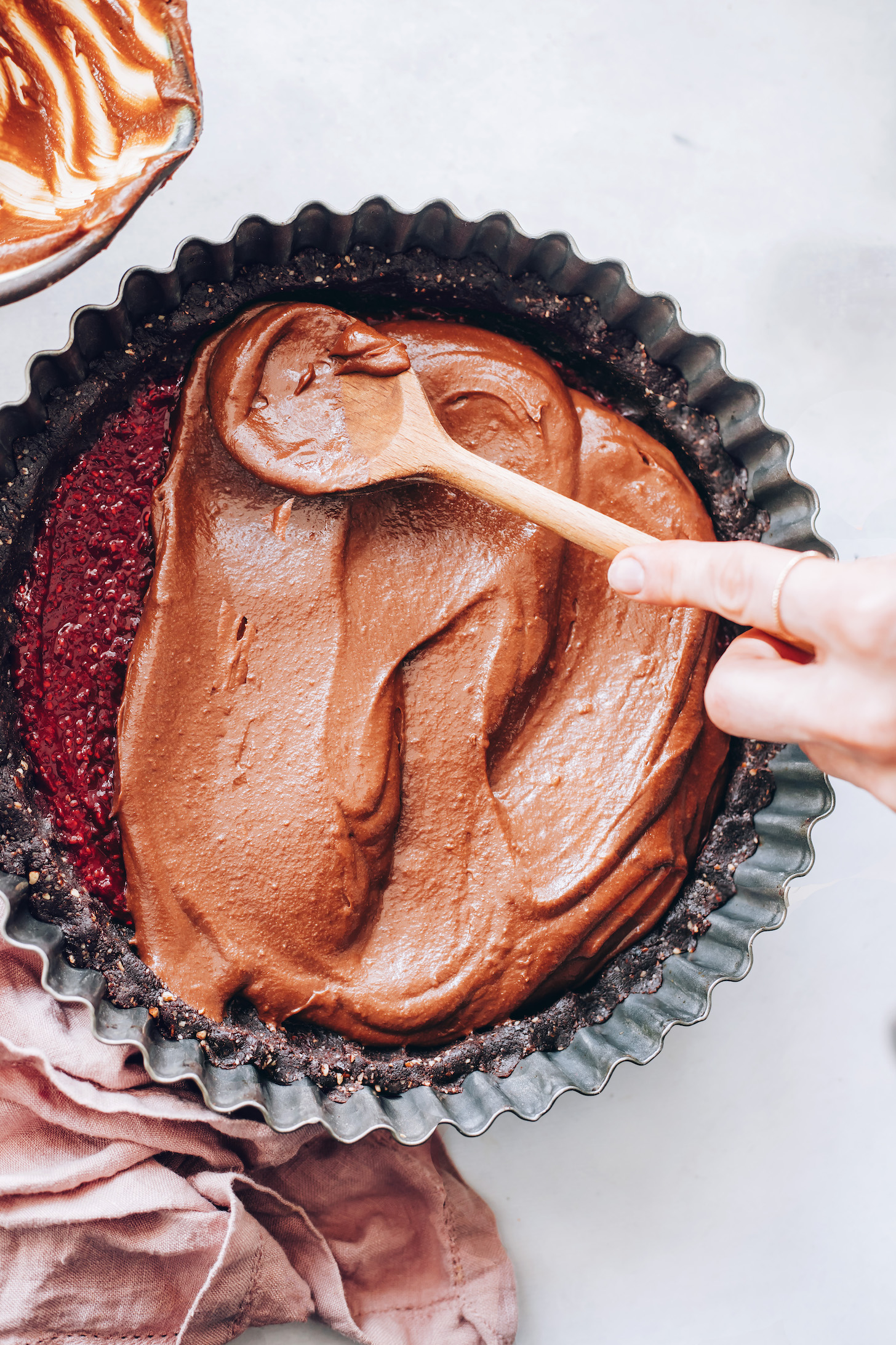 Adding the cashew chocolate ganache layer to the tart