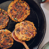Flipping a sweet potato fritter in a skillet