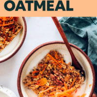 Bowl with a square of Carrot Cake Baked Oatmeal, shredded carrots, and dairy-free milk