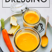 Jar of vegan & gluten-free carrot ginger dressing with fresh carrots and ginger
