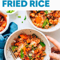 Hands resting on a bowl of Kimchi Fried Rice