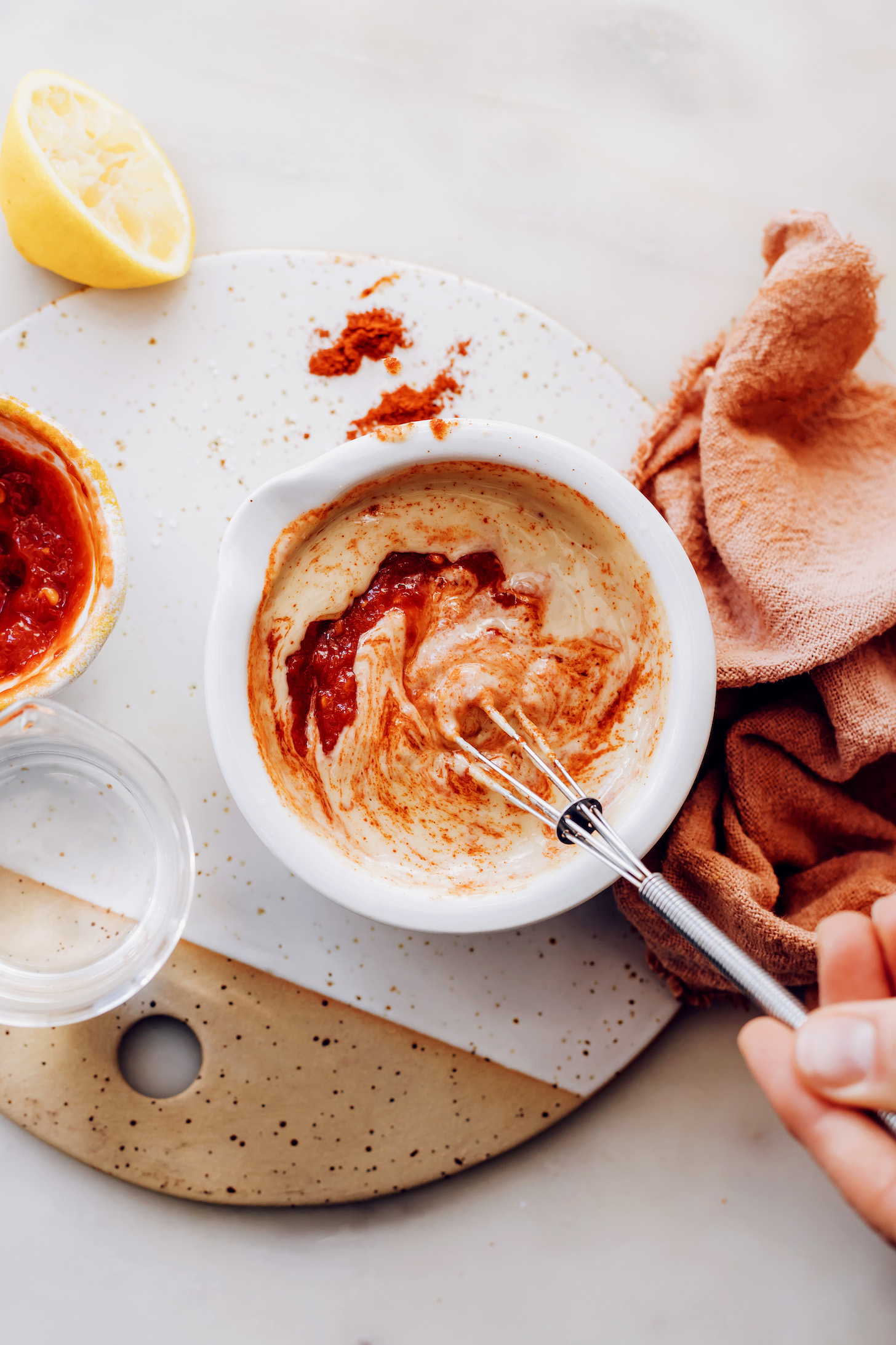 Whisking harissa with other ingredients to make harissa tahini sauce