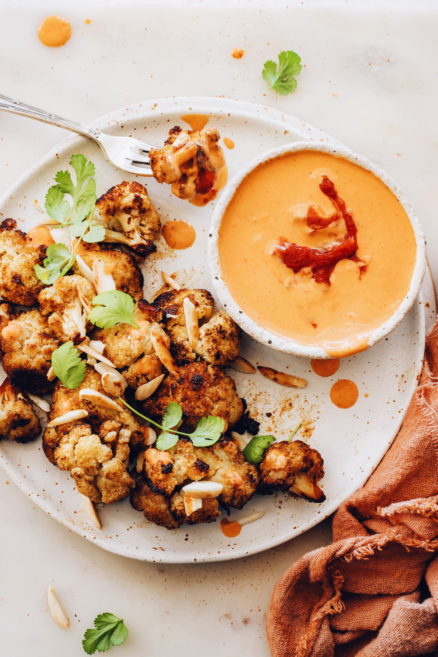 Plate of crispy cauliflower and bowl of harissa tahini sauce