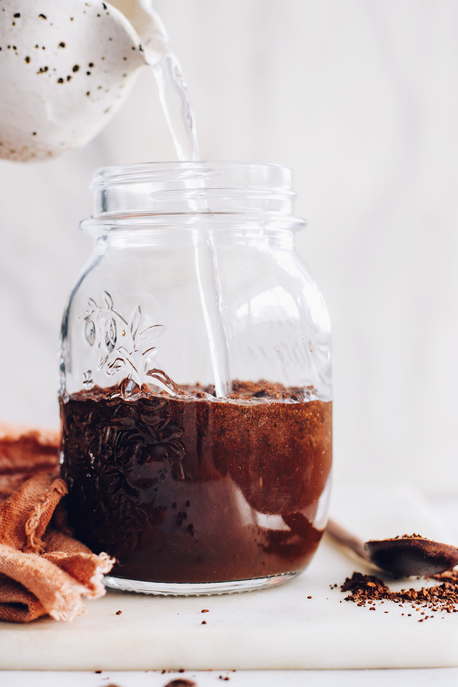 Pouring water over ground coffee to make cold brew
