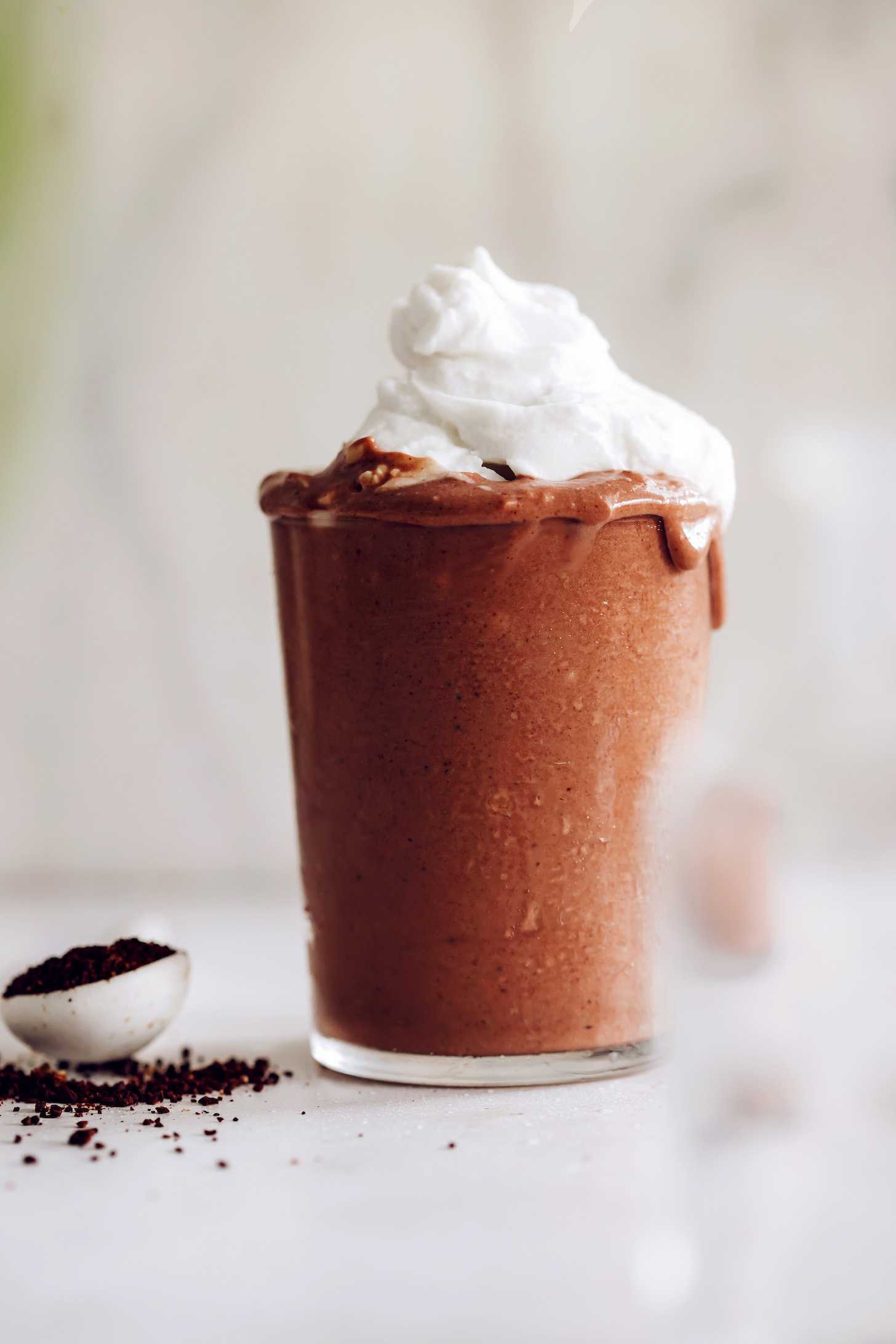Overflowing glass of our healthier jamocha shake recipe topped with coconut whipped cream
