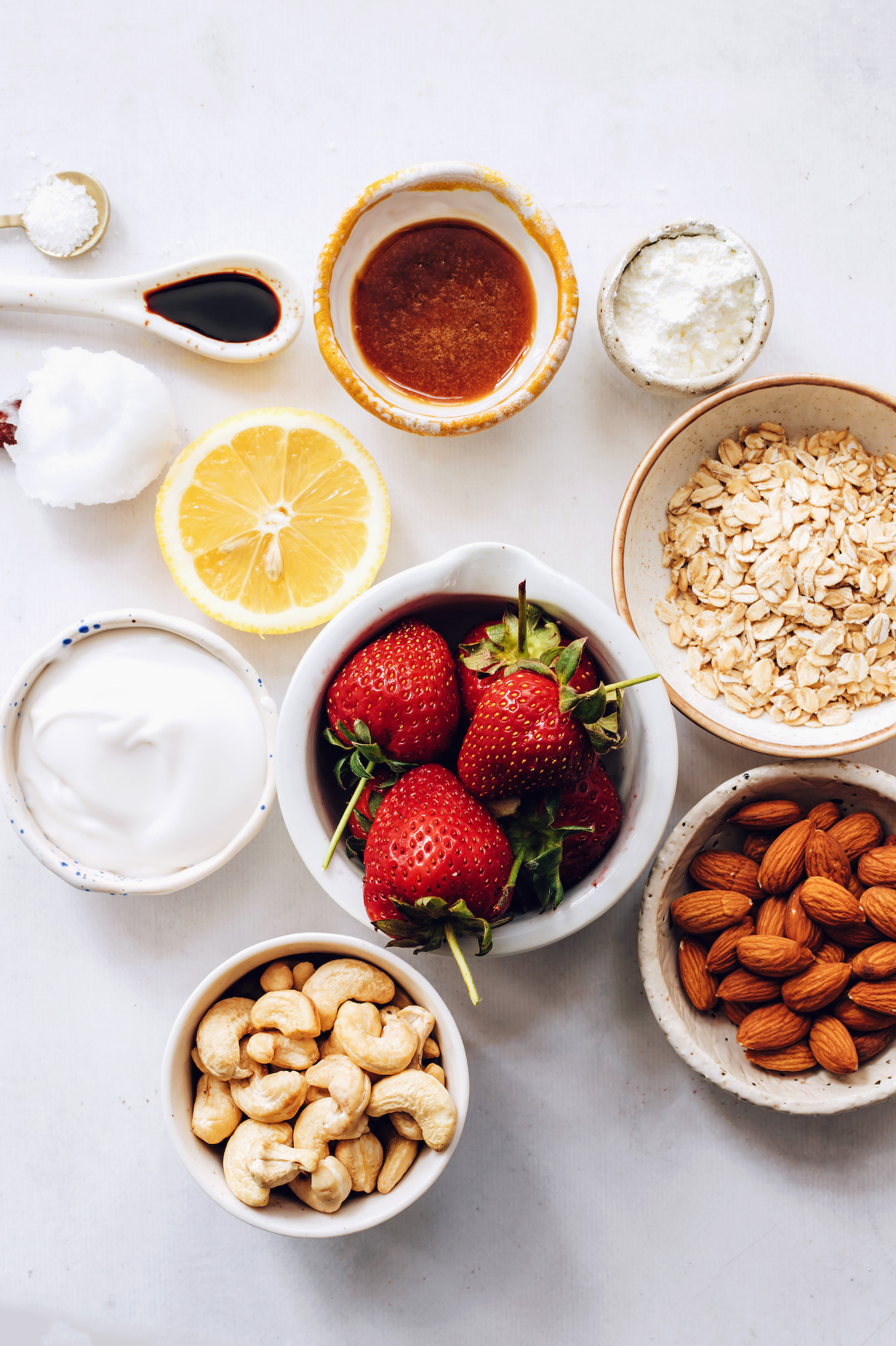 Cashews, almonds, oats, strawberries, coconut cream, lemon, cornstarch, maple syrup, vanilla, coconut oil, and salt
