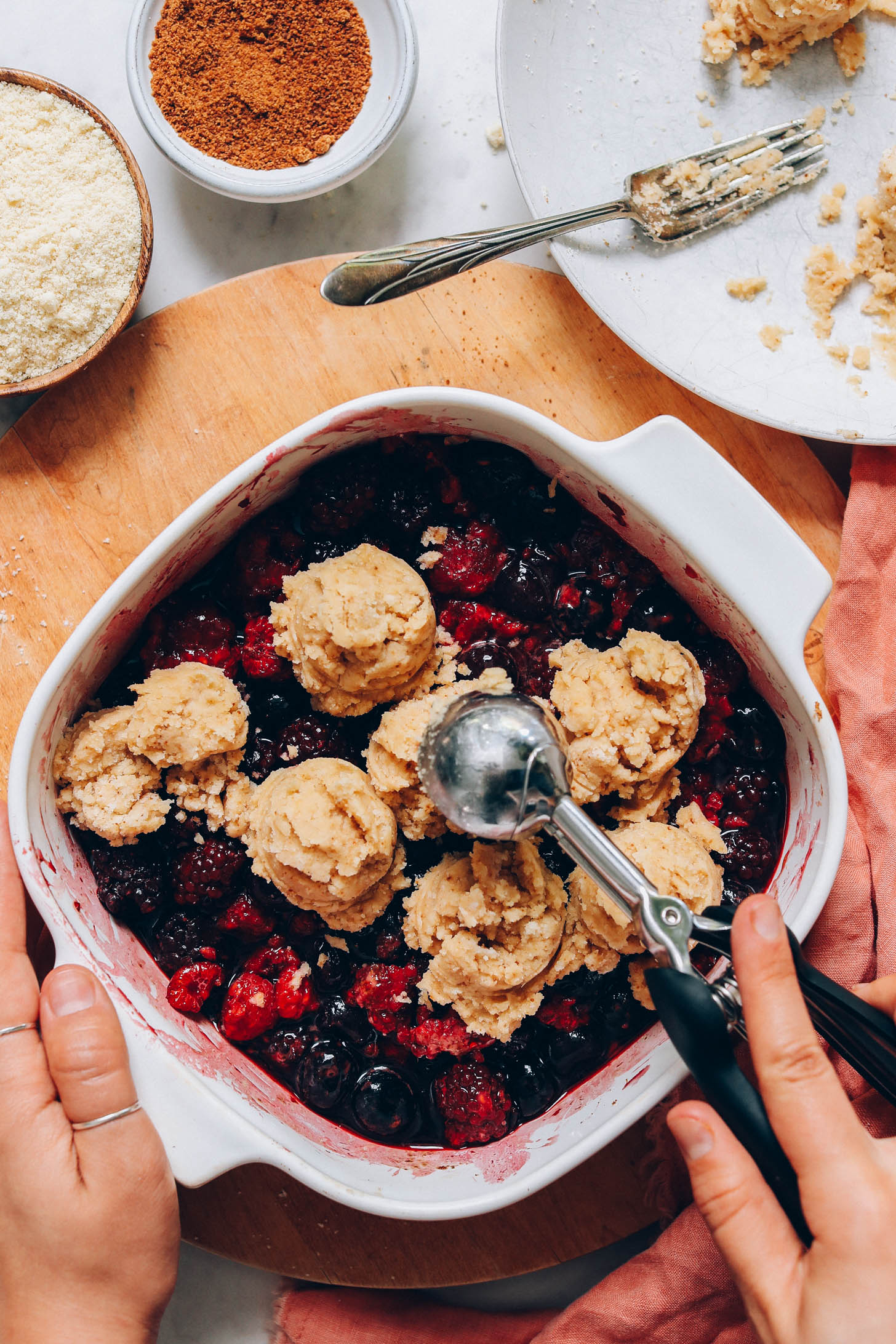 Scooping biscuit dough over macerated berries