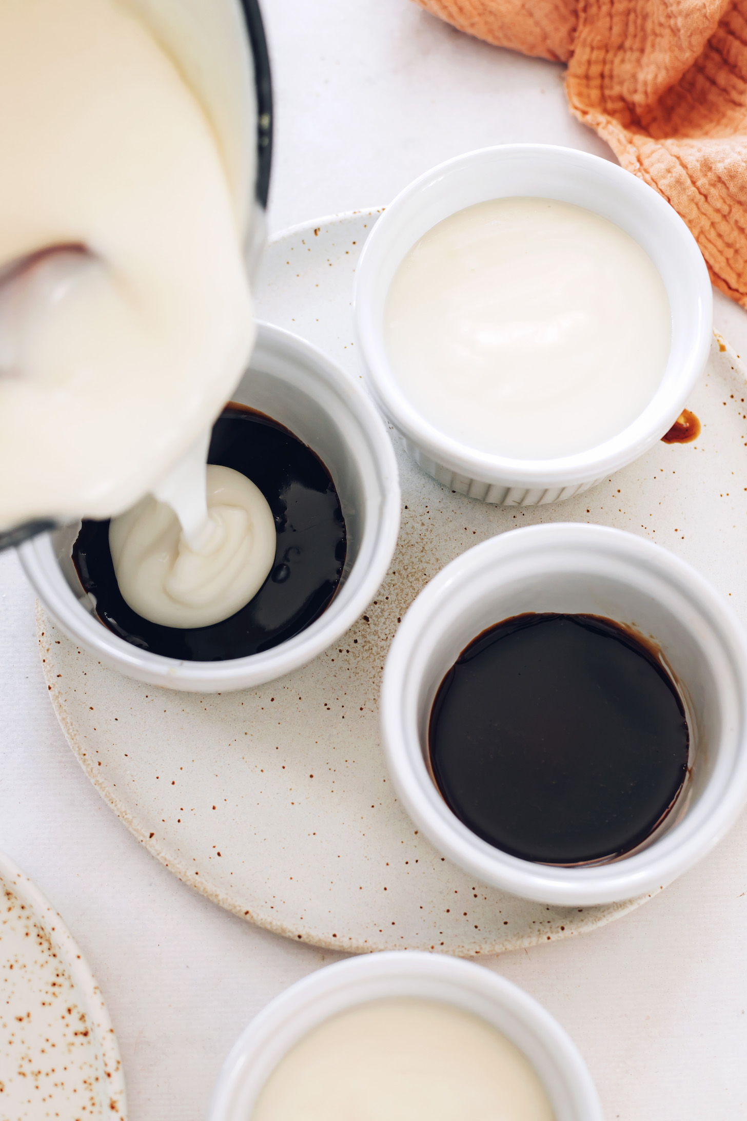 Pouring the creamy coconut custard layer over the salted caramel sauce