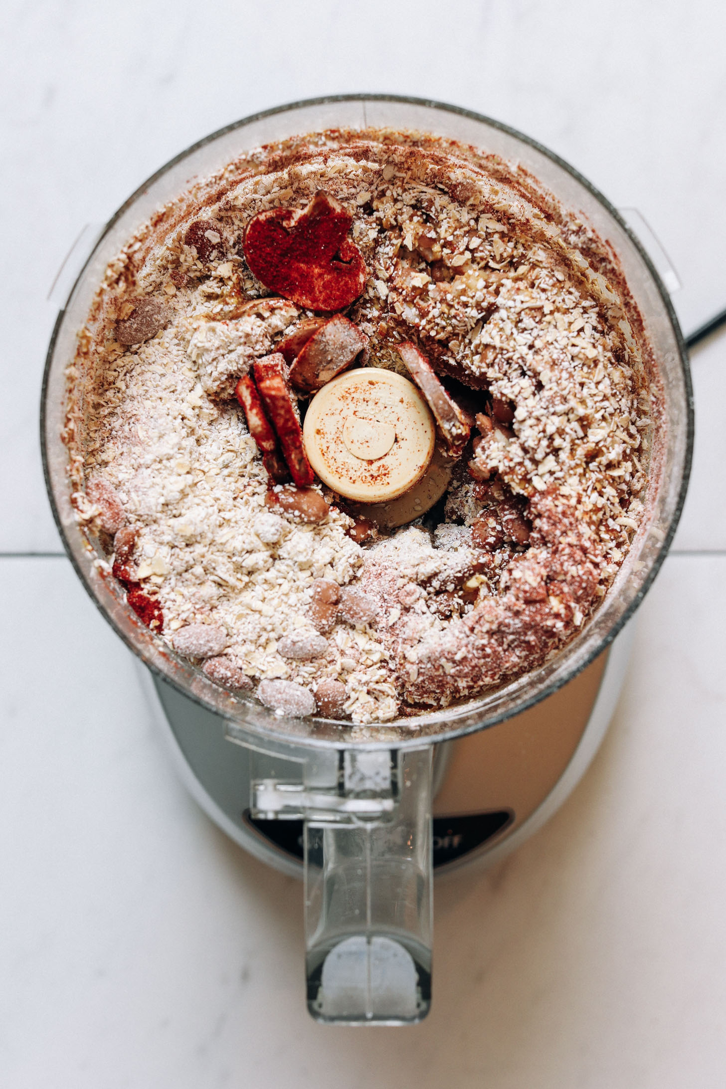 Food processor with oats, mushrooms, pinto beans, spices, and other ingredients