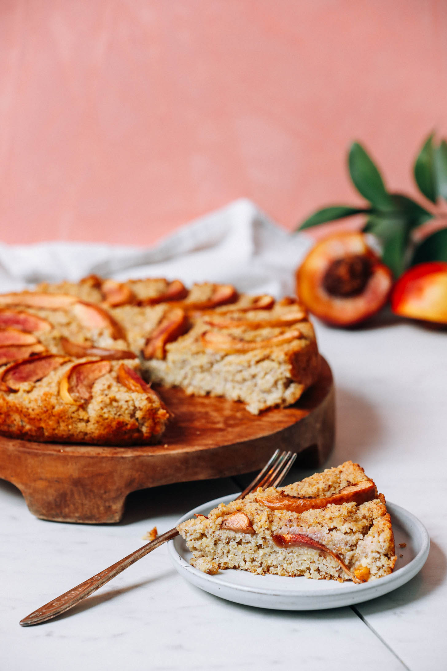 Slice of millet breakfast cake next to a tray with more cake