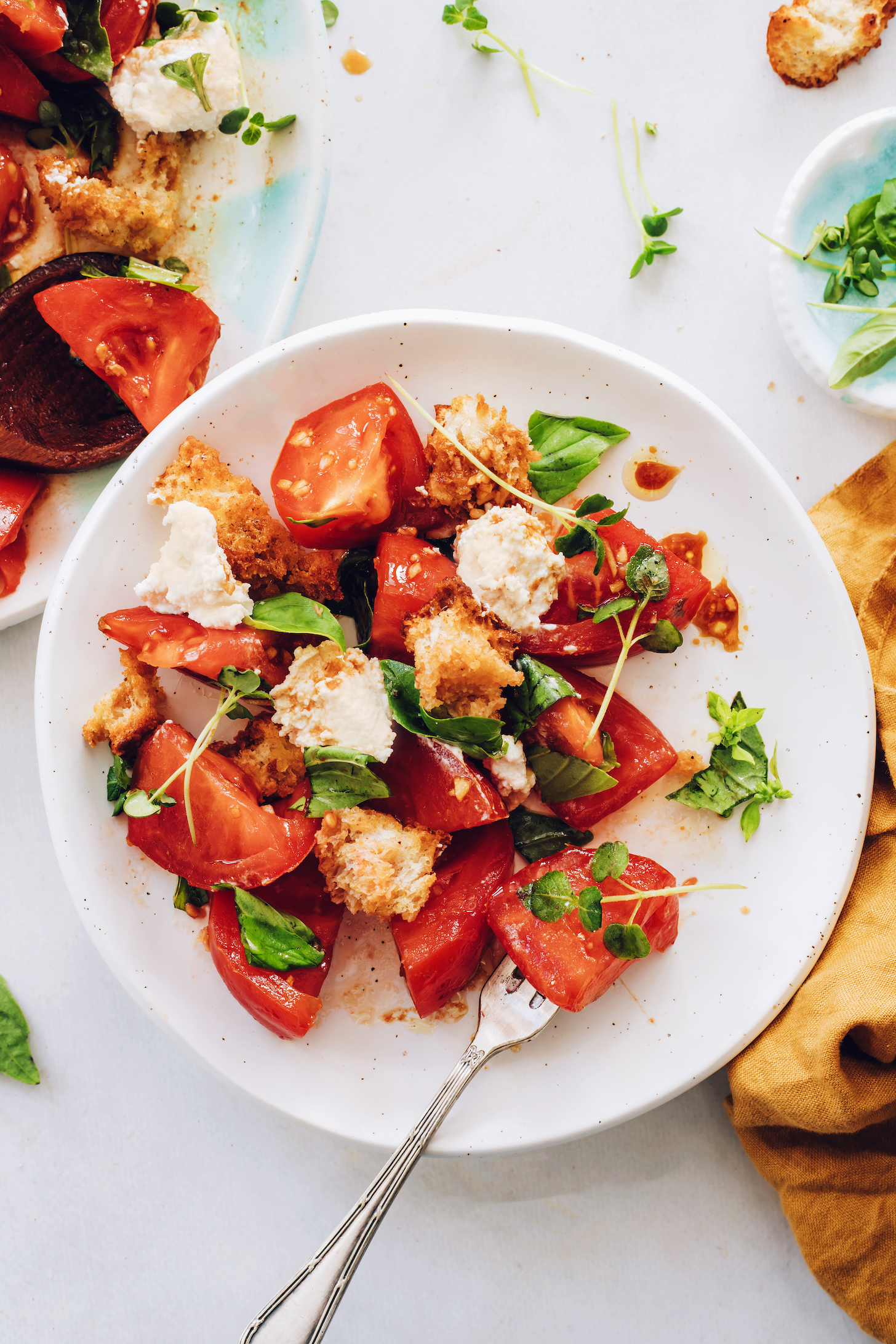 Fork in a bowl of heirloom tomato caprese panzanella salad