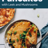 Plate of savory chickpea pancakes folded with leeks and mushrooms inside on a blue towel