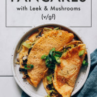 Plate of savory chickpea pancakes folded with leeks and mushrooms