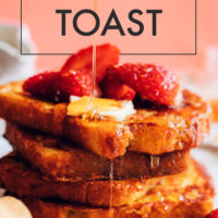 A stack of easy vegan french toast with raspberries, maple syrup, and vegan butter