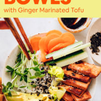 A vegan sushi bowl with fresh chopped veggies, marinated tofu, and tamari on the side with chopsticks