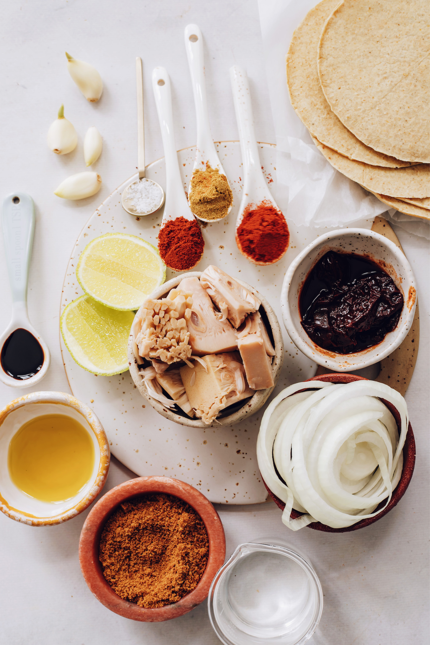 Garlic, salt, lime, spices, jackfruit, adobo pepper, onion, corn tortillas, water, oil, and coconut aminos