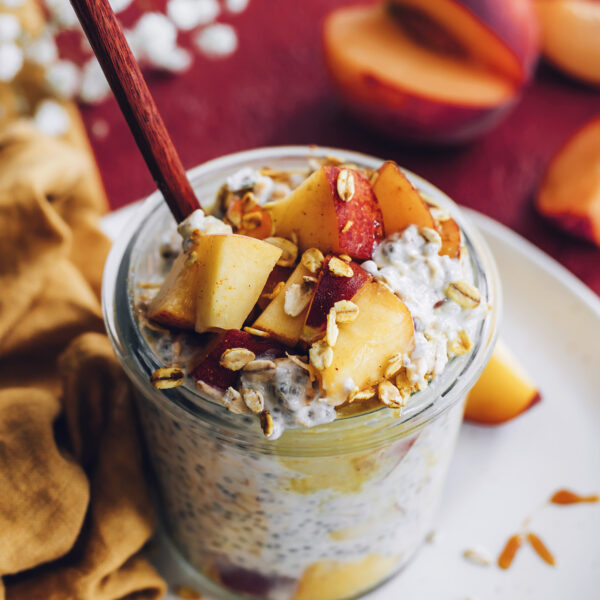 Spoon in a jar of peaches n cream overnight oats