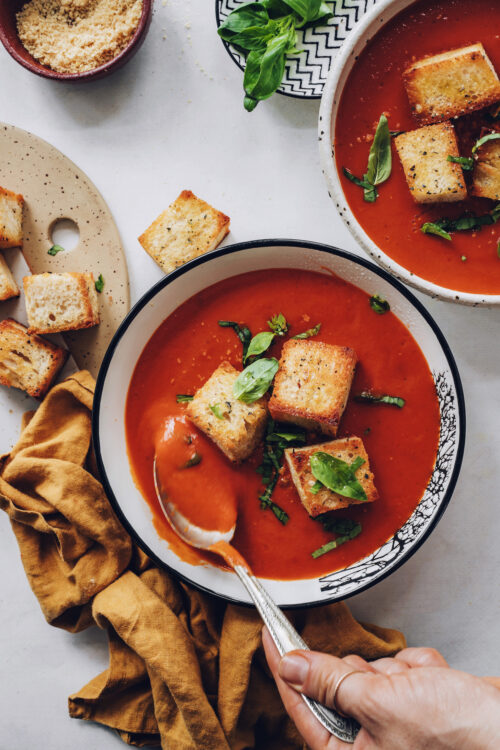 Spoon in a bowl of creamy tomato soup