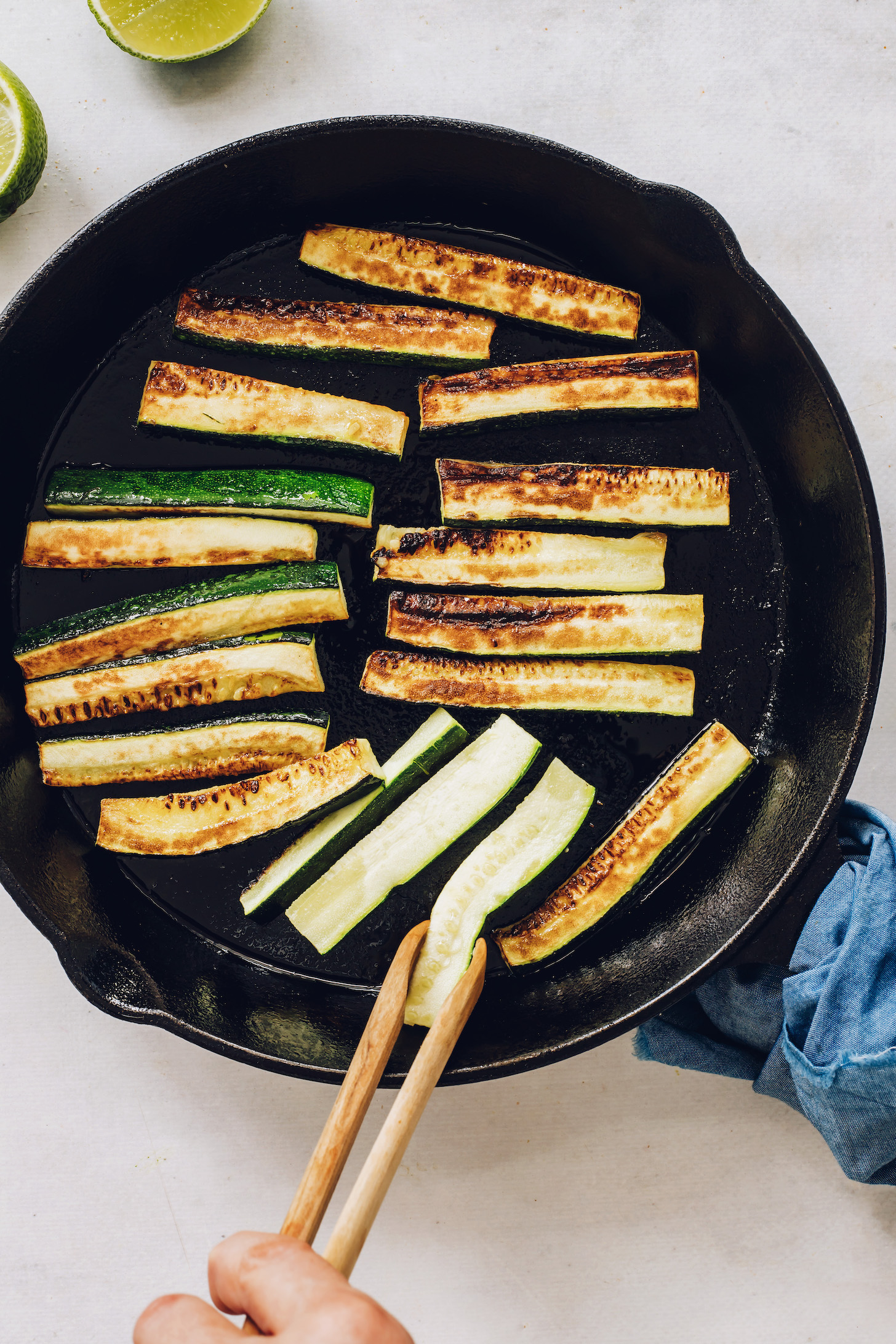 Cooking zucchini slices in a cast iron skillet