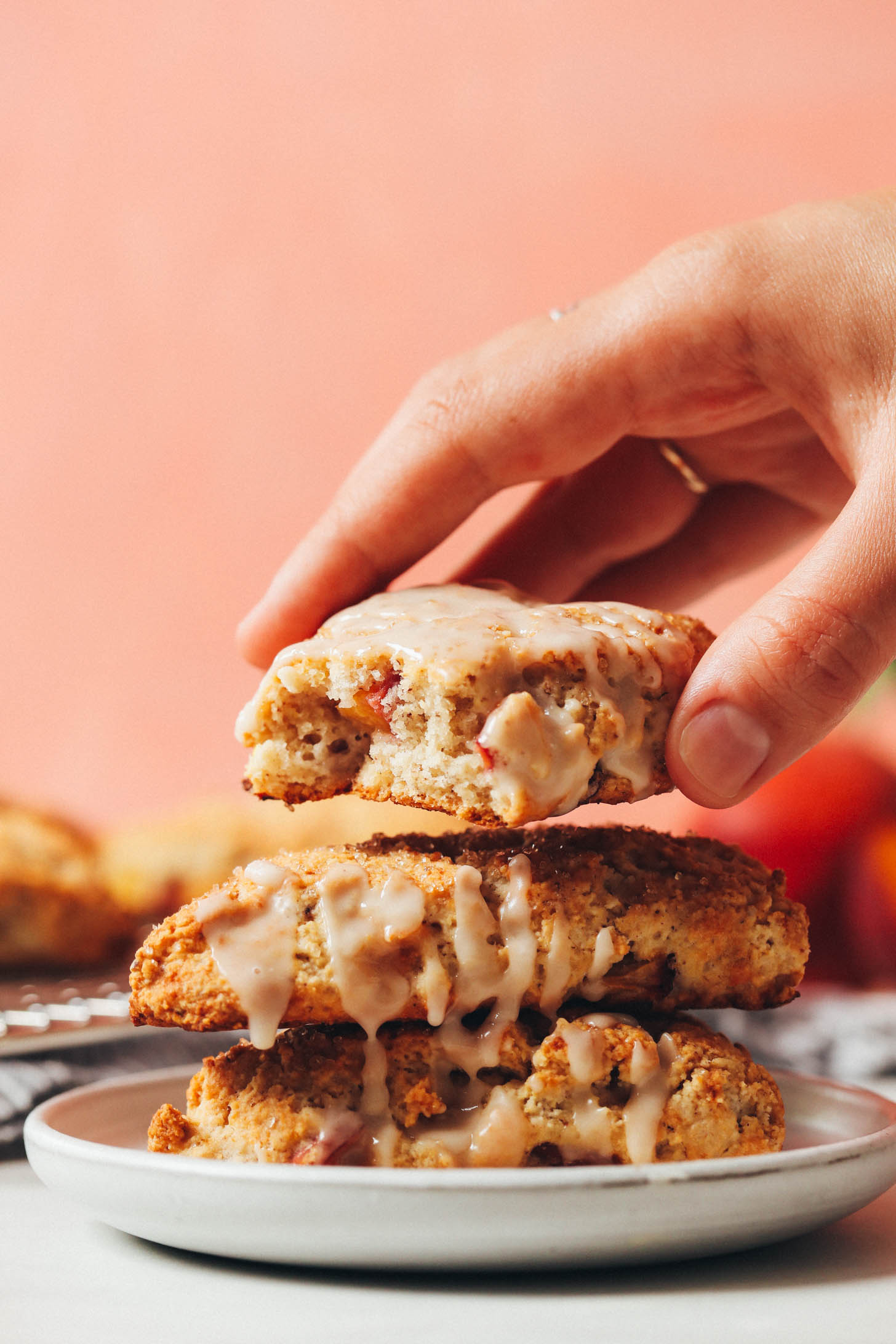 Picking up a peach scone to show the fluffy texture on the inside