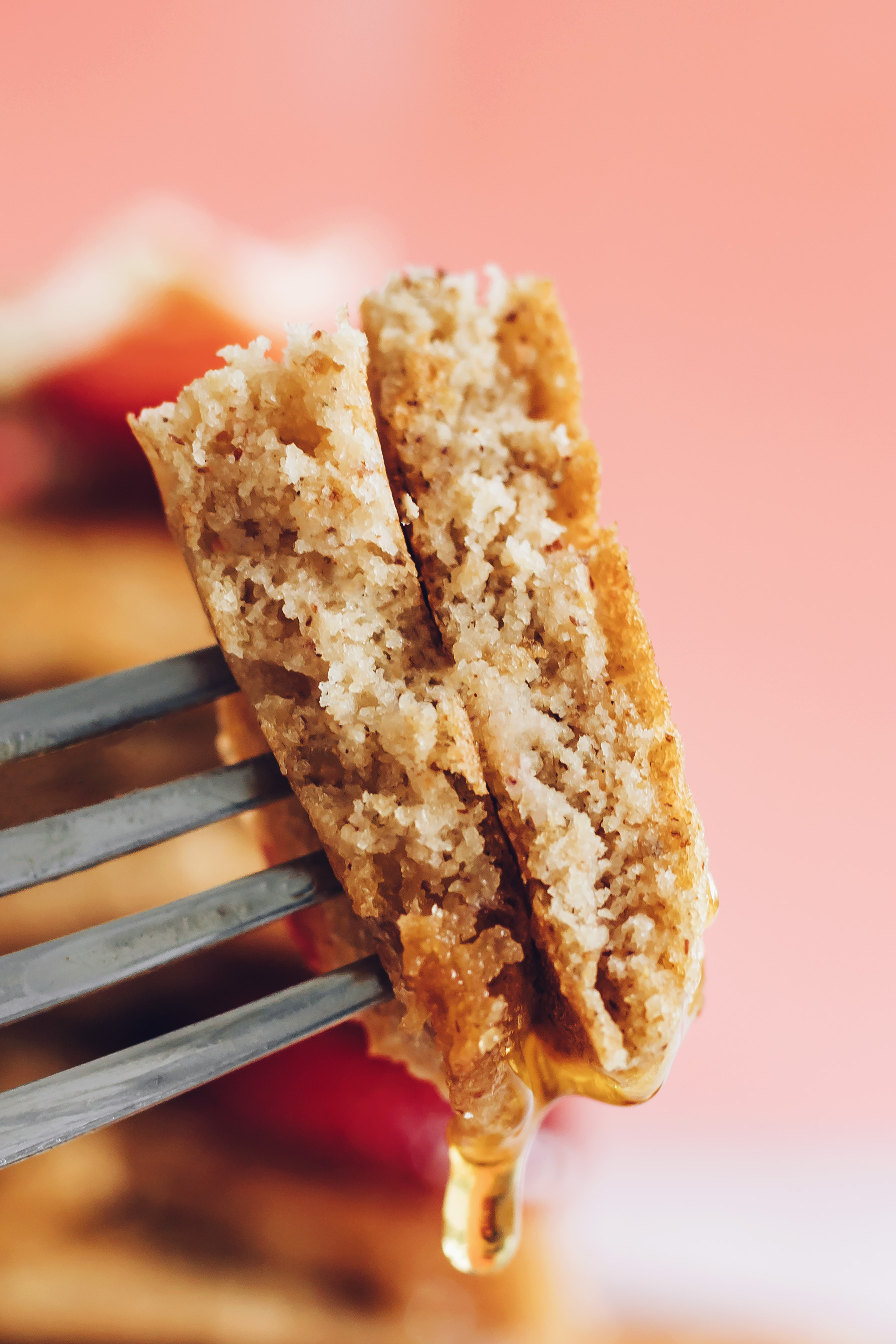 Maple syrup dripping from a bite of gluten-free pancakes