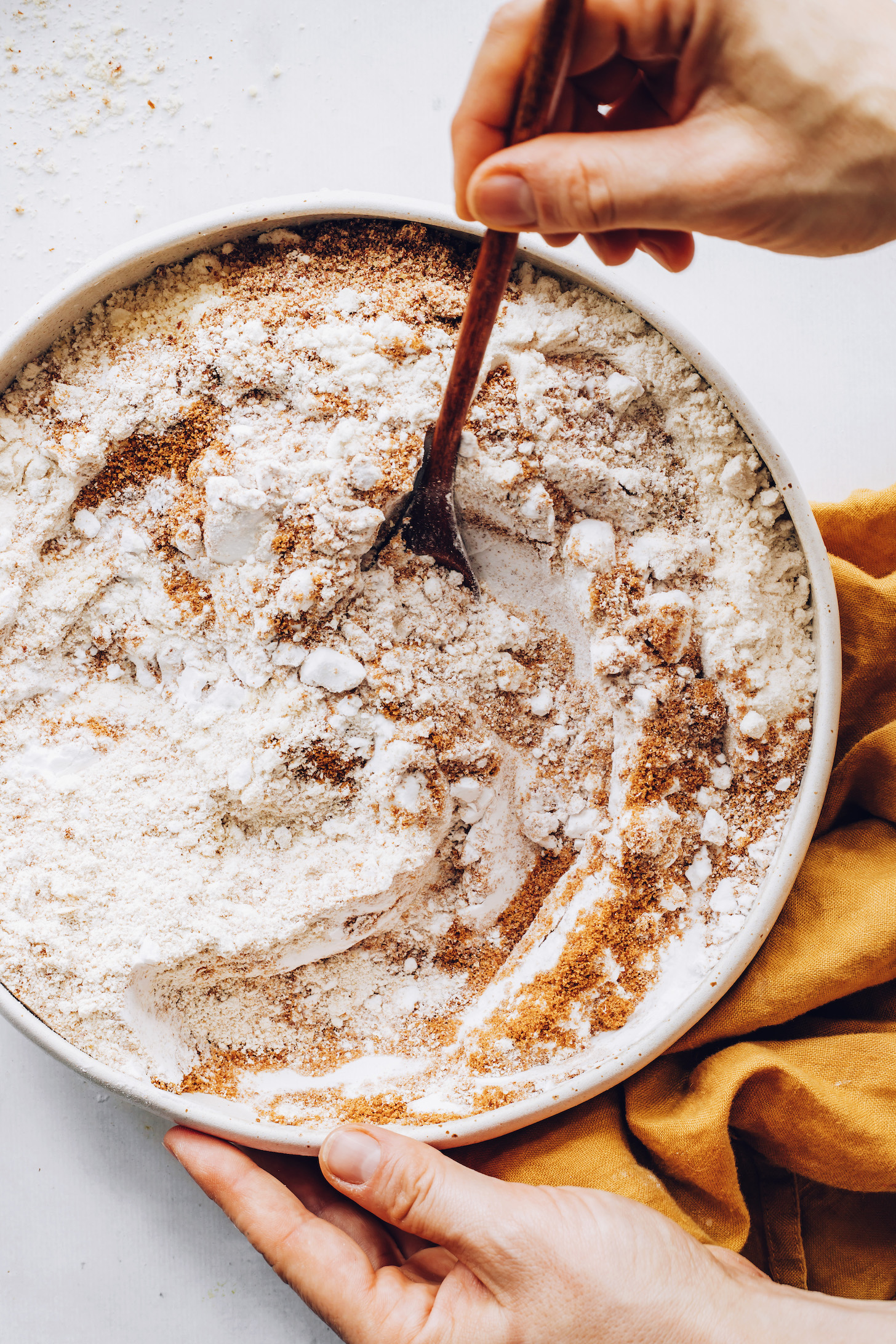 Stirring gluten-free flours, flaxseed, and coconut sugar in a mixing bowl