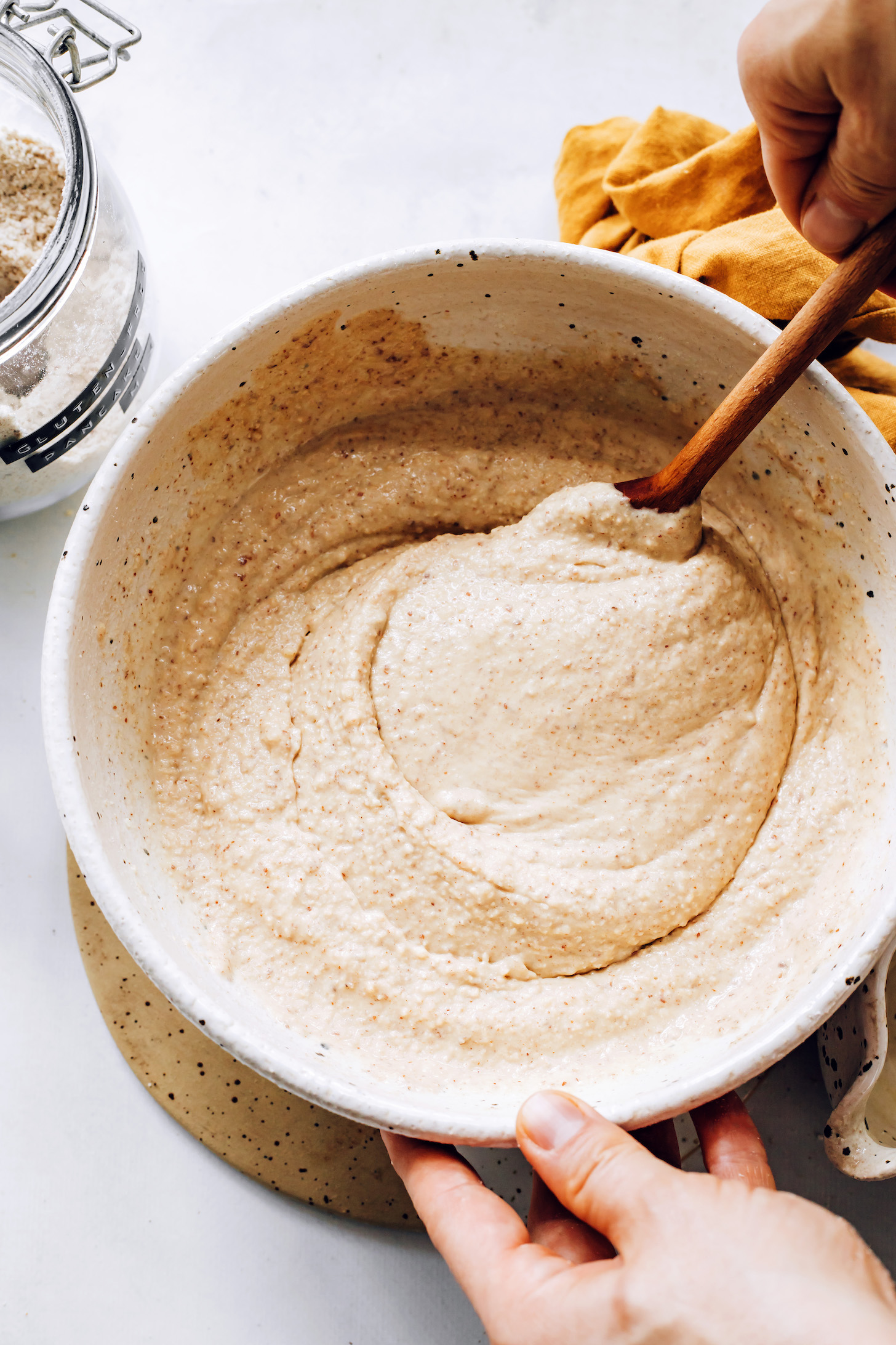 Wooden spoon stirring a bowl of gluten-free pancake batter