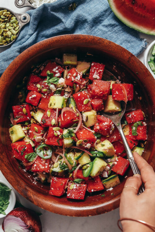 Vintage spoon in a bowl of watermelon salad with fresh cucumber and mint