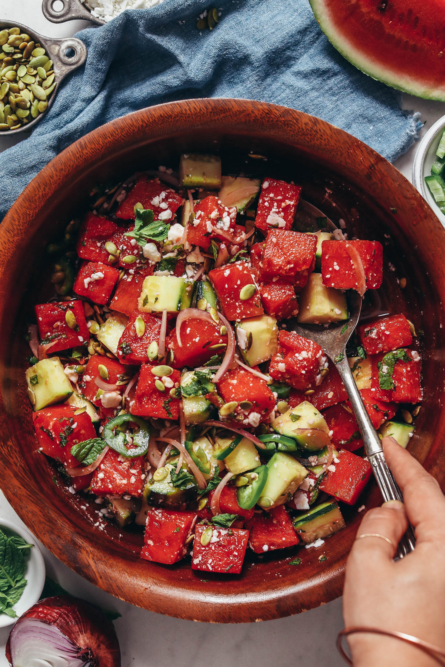 Wood serving bowl filled with minty watermelon cucumber salad