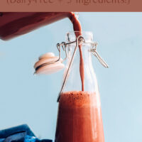 Glass container of creamy vegan chocolate hazelnut milk