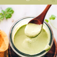 Jar of vegan and gluten-free cilantro sunflower seed dressing with a spoon in it