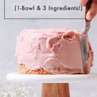 Vegan strawberry frosting being spread on a strawberry cake