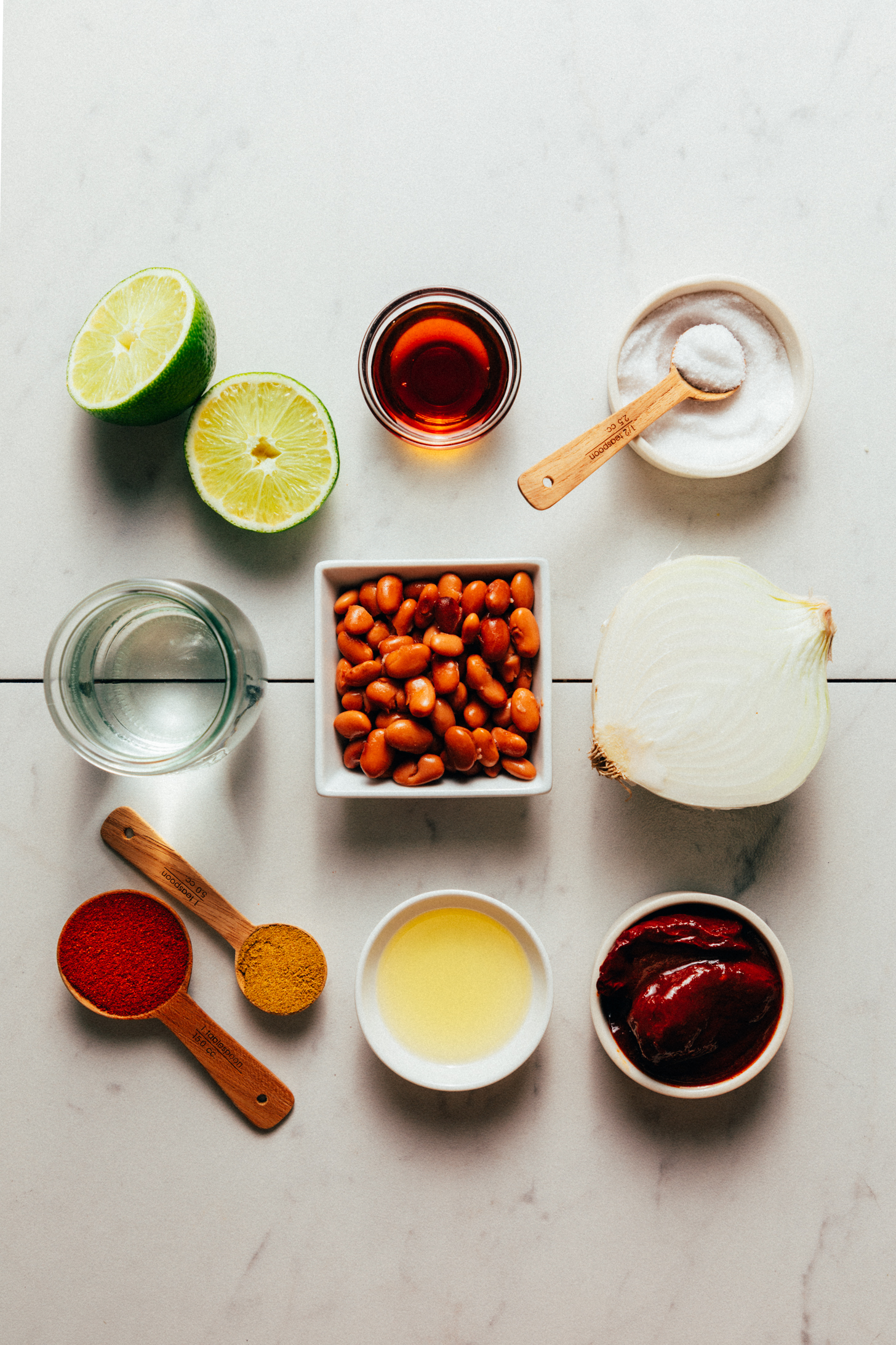 Limes, maple syrup, salt, onion, chipotle peppers, oil, cumin, smoked paprika, pinto beans, and water