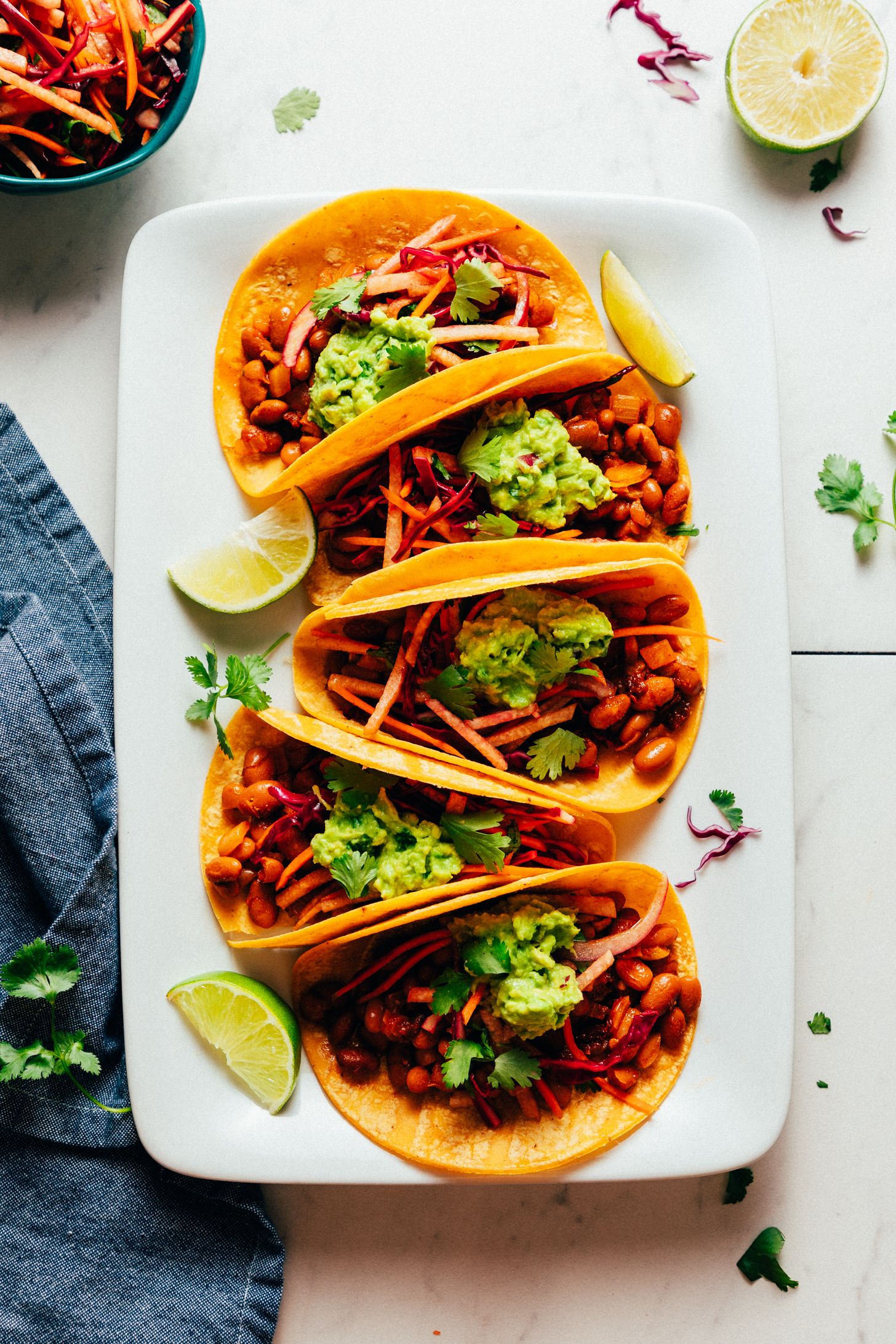 Platter of smoky BBQ bean vegan tacos with guacamole and jicama slaw