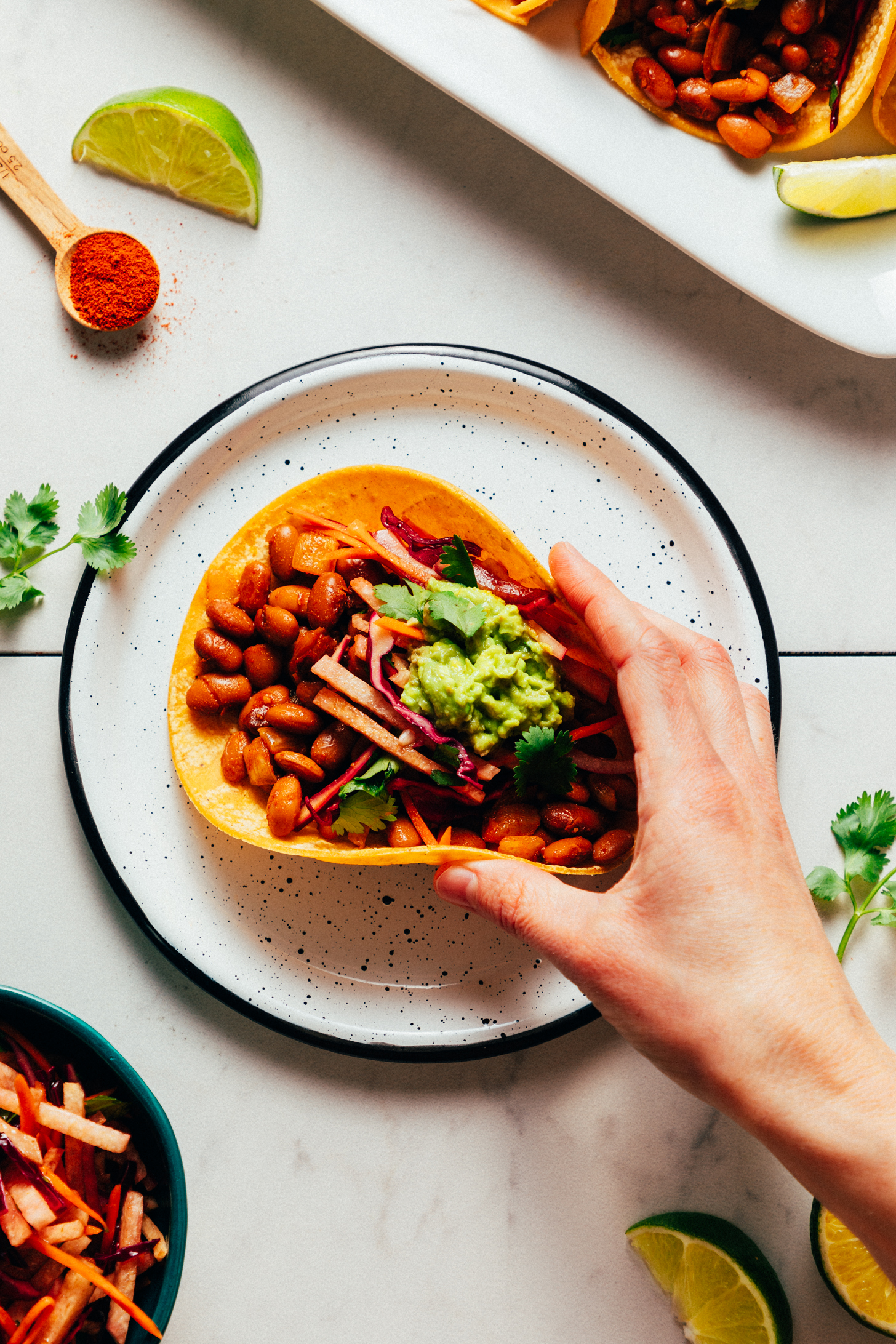 Picking up a BBQ bean taco from a plate
