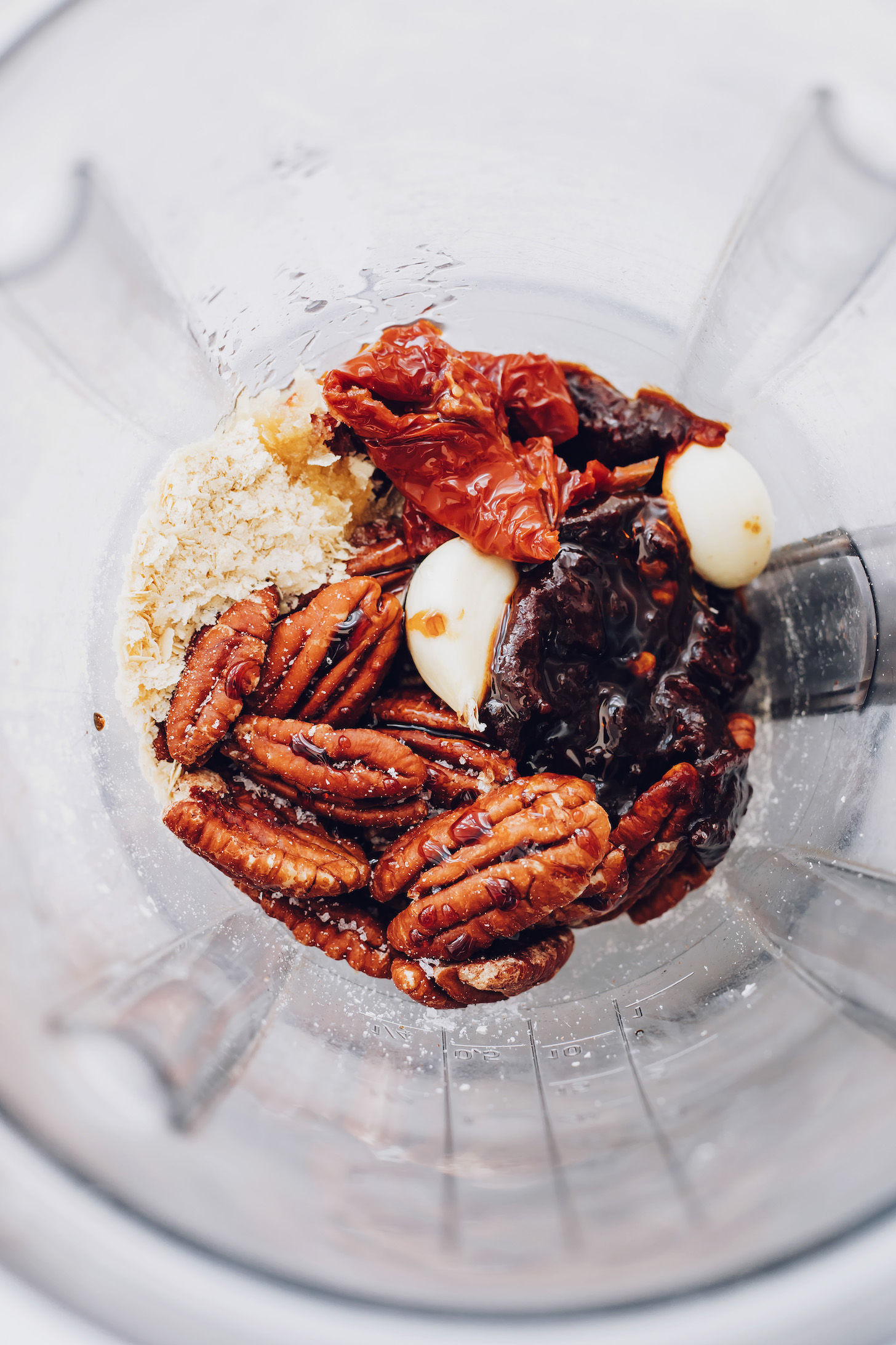 Blender with pecans, garlic, sun-dried tomatoes, salt, chipotle peppers, and nutritional yeast