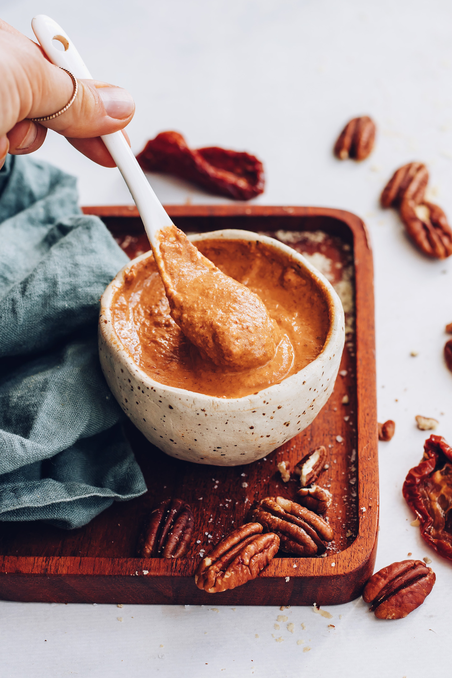 Holding a spoon of chipotle pecan pesto over a bowl of more pesto