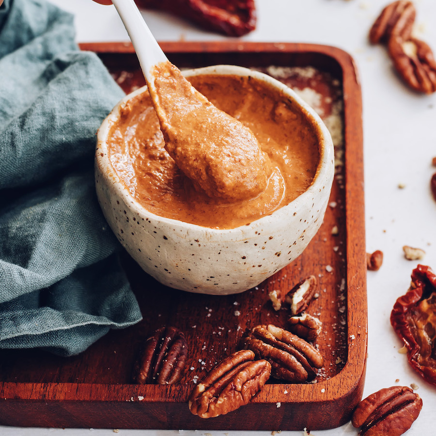Spoon in a bowl of creamy chipotle pecan pesto