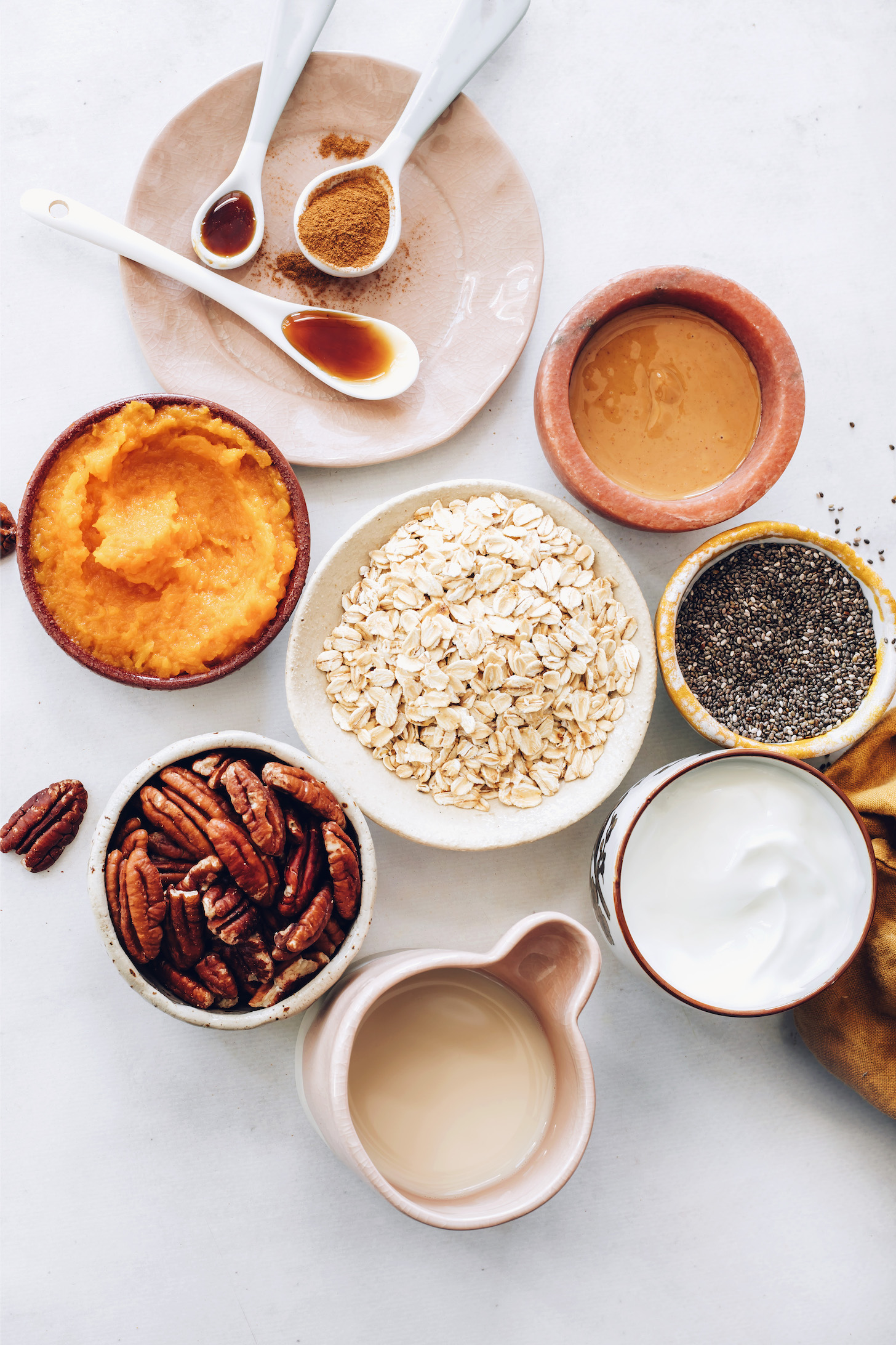 Maple syrup, vanilla, pumpkin pie spice, almond butter, chia seeds, coconut yogurt, oats, pumpkin purée, pecans, and almond milk