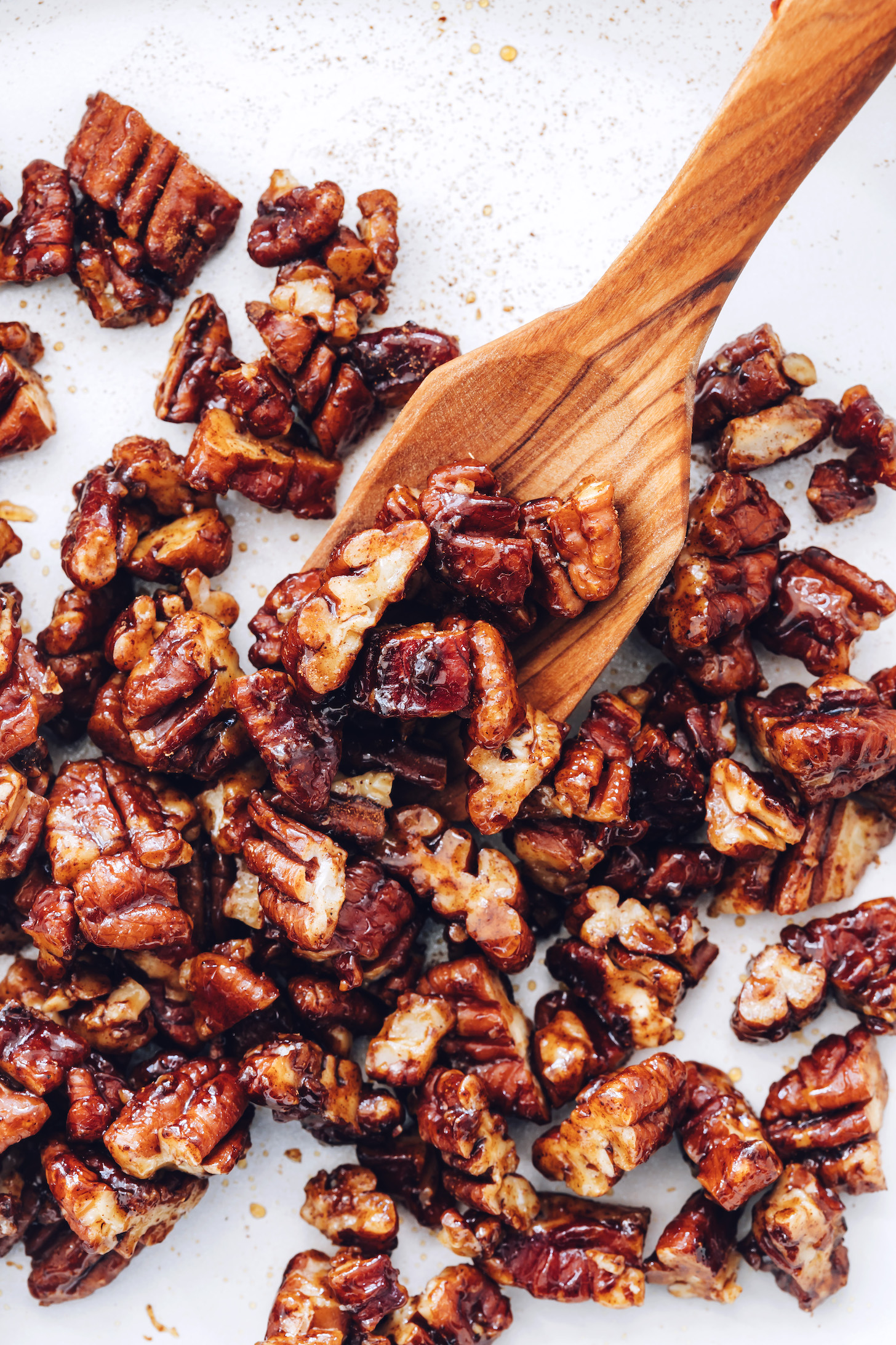 Wooden spoon holding candied pecans