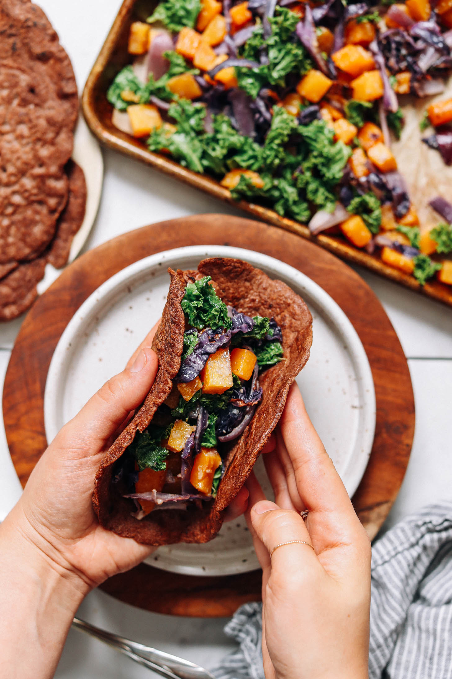 Folding a savory teff crepe stuffed with roasted vegetables