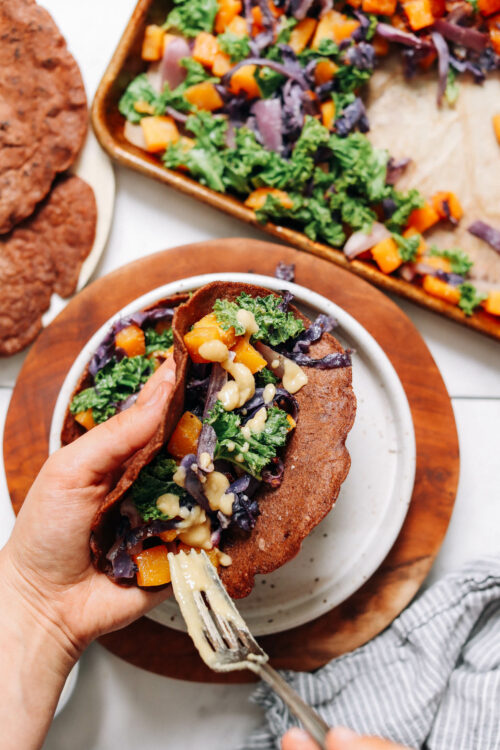 Spreading miso onto a savory crepe made with teff and fall vegetables