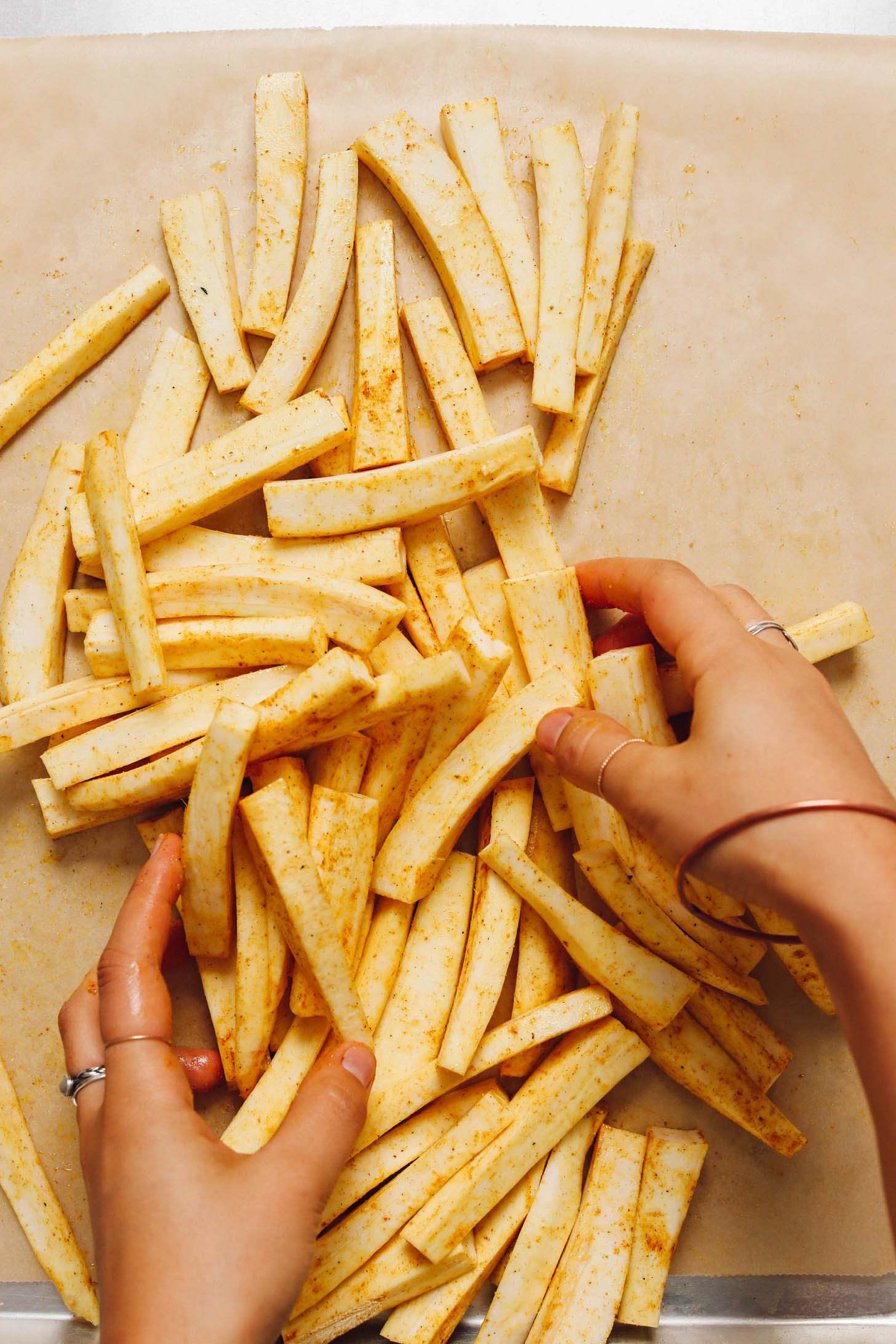 Tossing sliced parsnips in curry powder