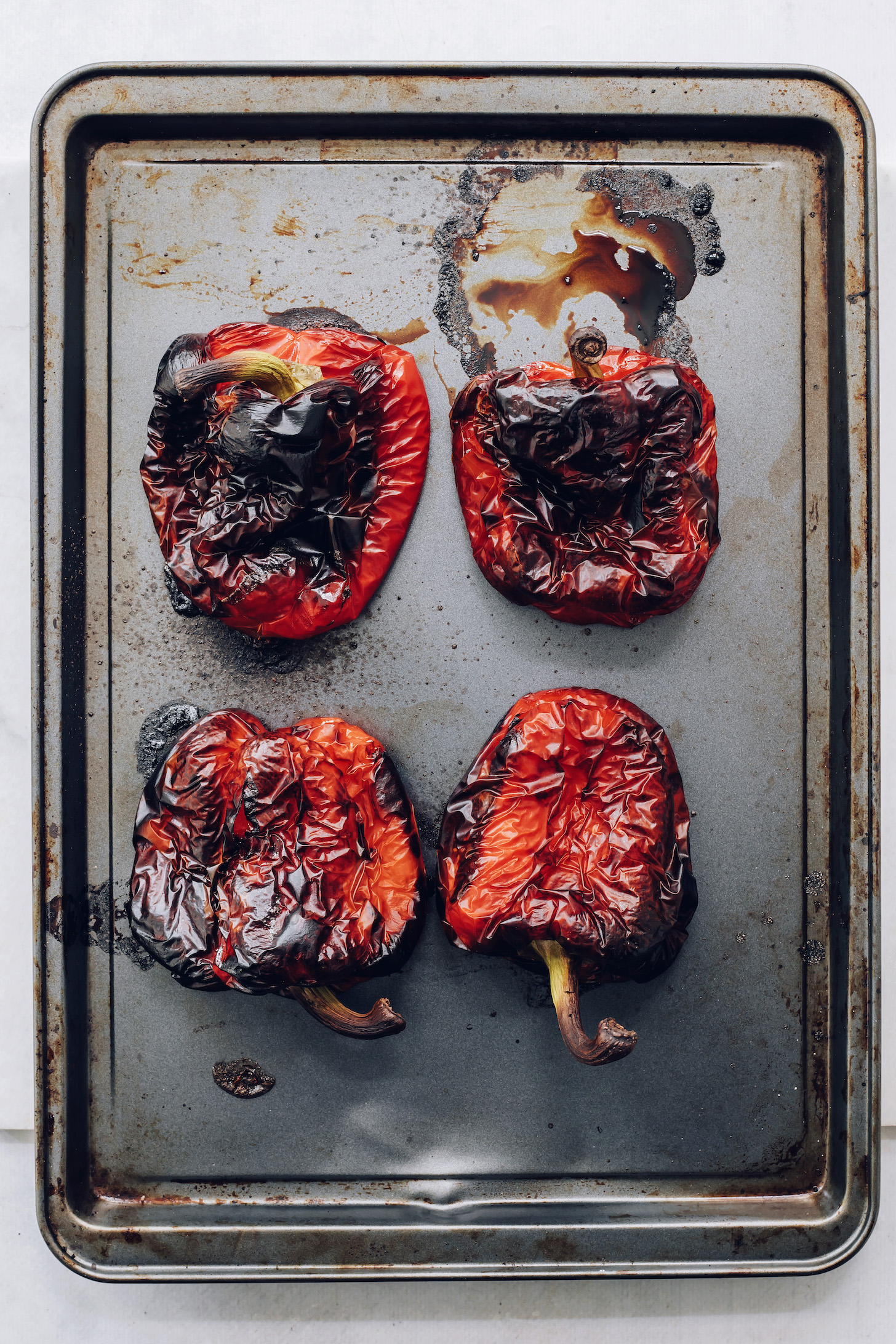 Baking sheet of roasted peppers for our tutorial on how to to make roasted red peppers