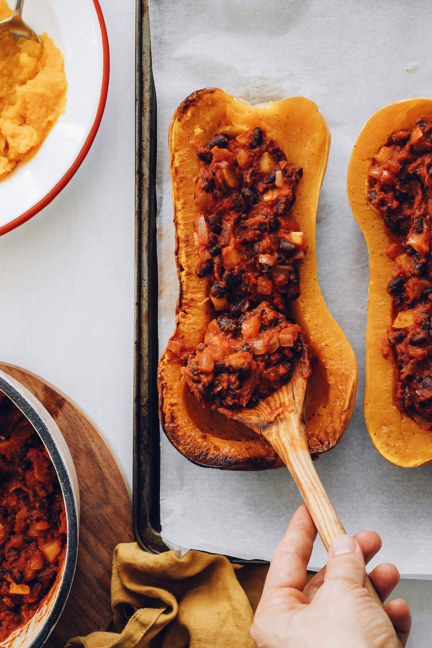 Adding black bean enchilada filling to roasted squash halves