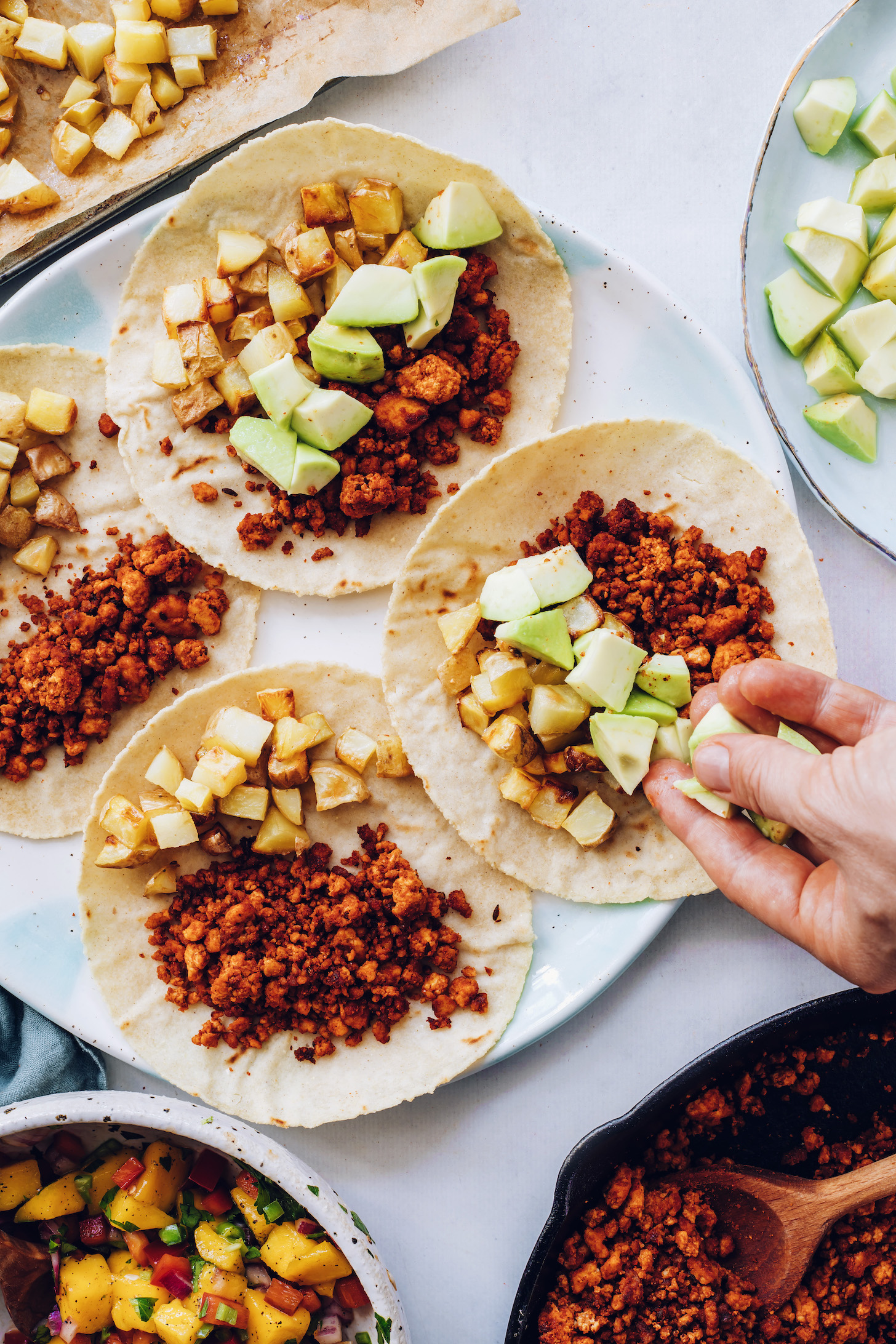 Adding cubed avocado to a taco