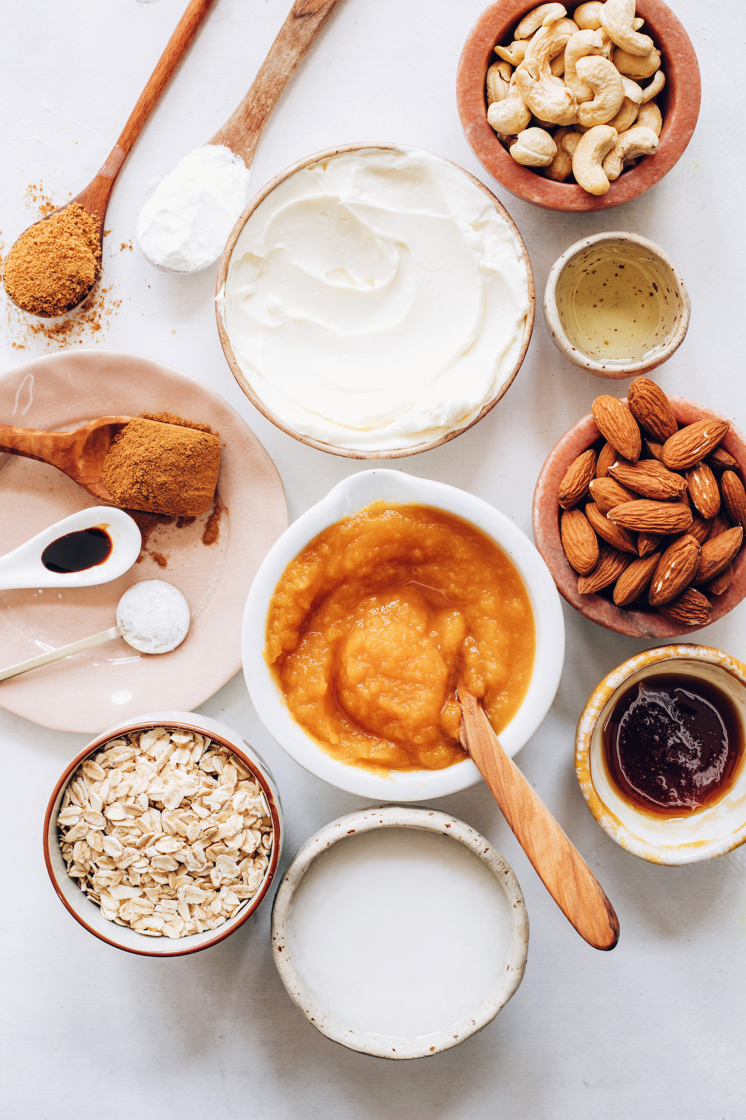 Cashews, coconut cream, coconut oil, almonds, maple syrup, almond, vegan cream cheese, oats, salt, vanilla, coconut sugar, and pumpkin pie spice